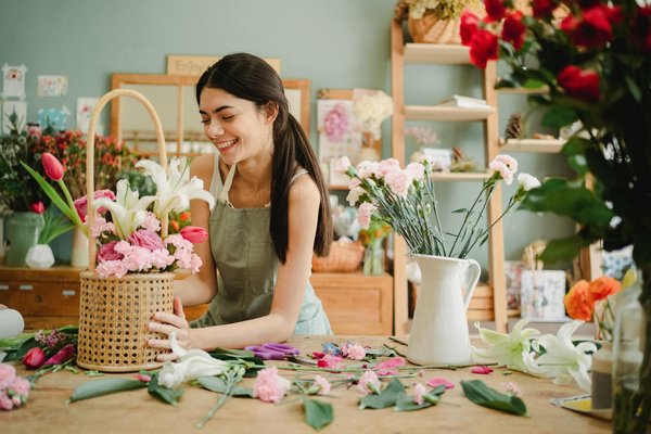 Femme réalisant un bouquet de fleurs – artisanat et couverture adaptée