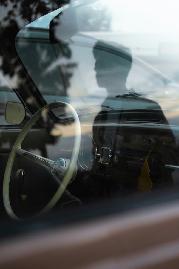 Personne se voyant dans le miroir de voiture – assurance obligatoire au Luxembourg