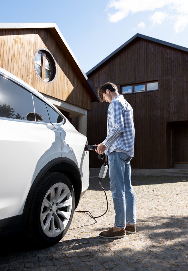 Jeune homme rechargeant son véhicule électrique – mobilité durable assurée