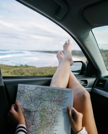 Femme jambes à la fenêtre avec feuille de route – assurance voyages
