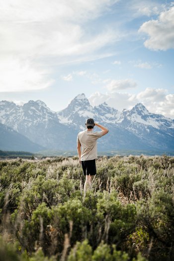 Homme contemplant les montagnes – projection d’avenir assurée